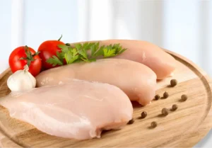 Raw chicken breasts on a wood cutting board