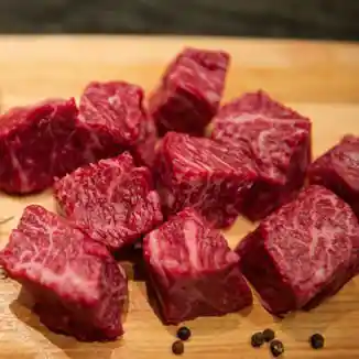 Cubed beef on a wood cutting board