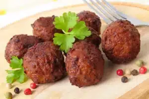 Roasted meatballs on a wood platter