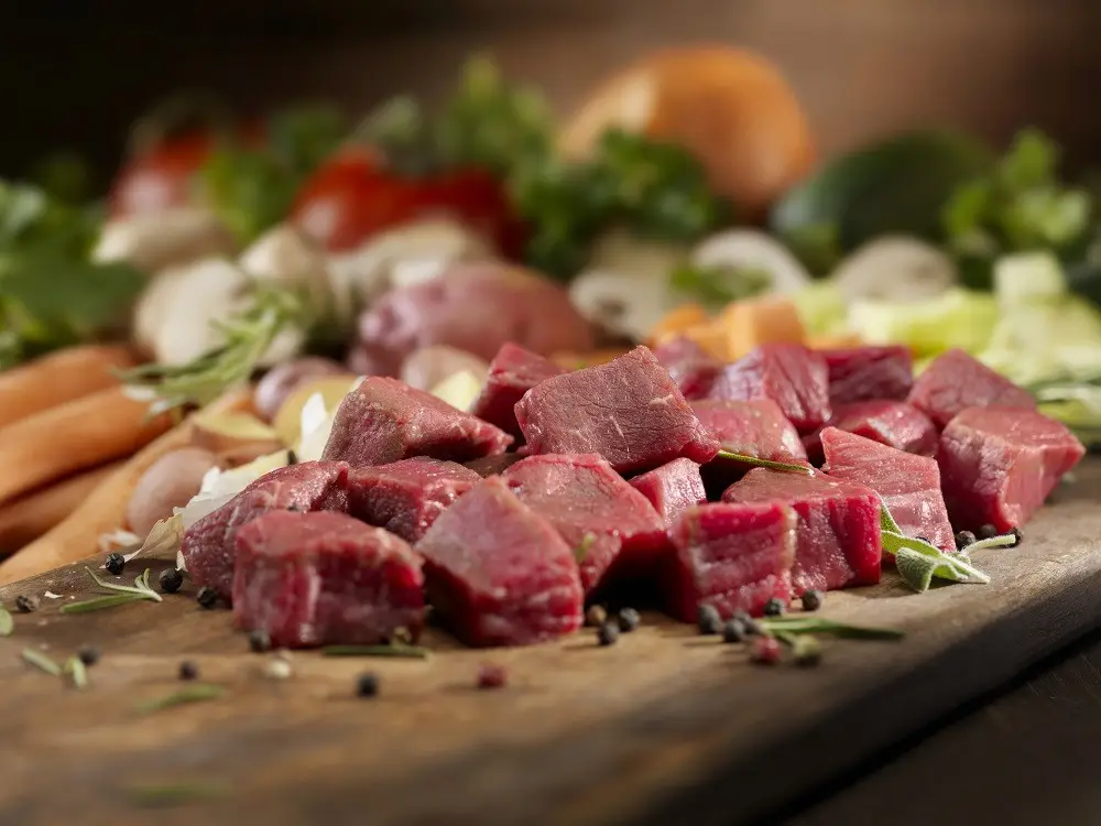 Beef cubes - diced - on a cutting board